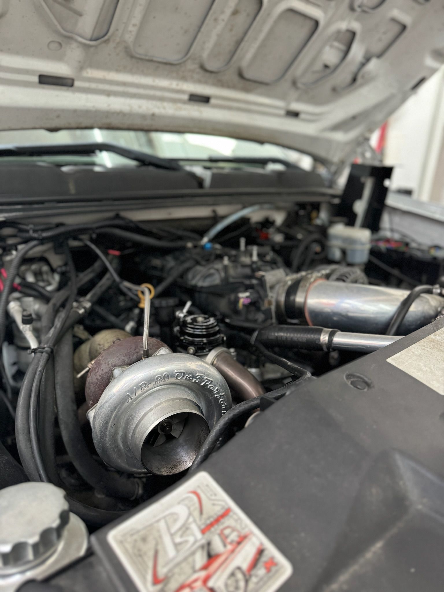A close up of a car engine with the hood up.