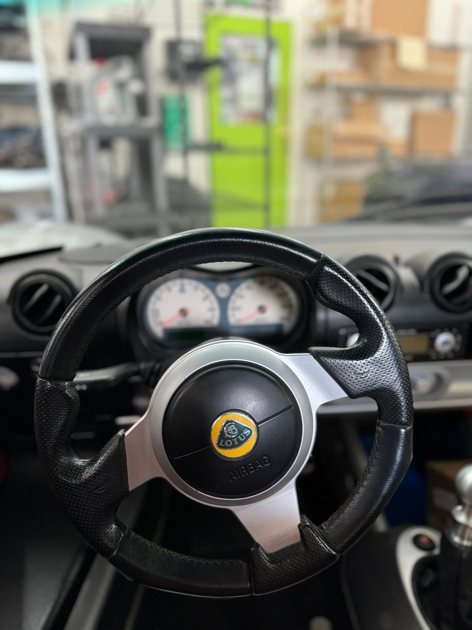 A close up of a steering wheel in a car in a garage.