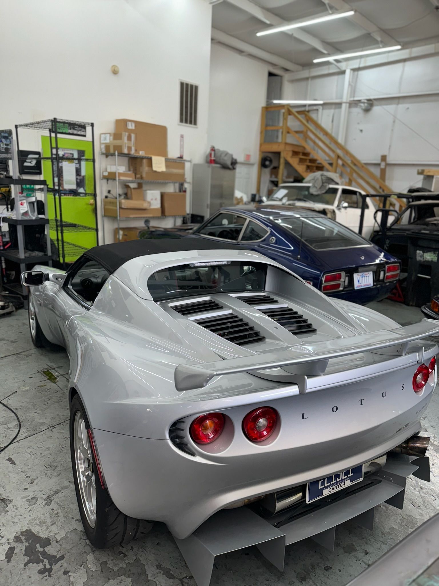 A silver sports car is parked in a garage.