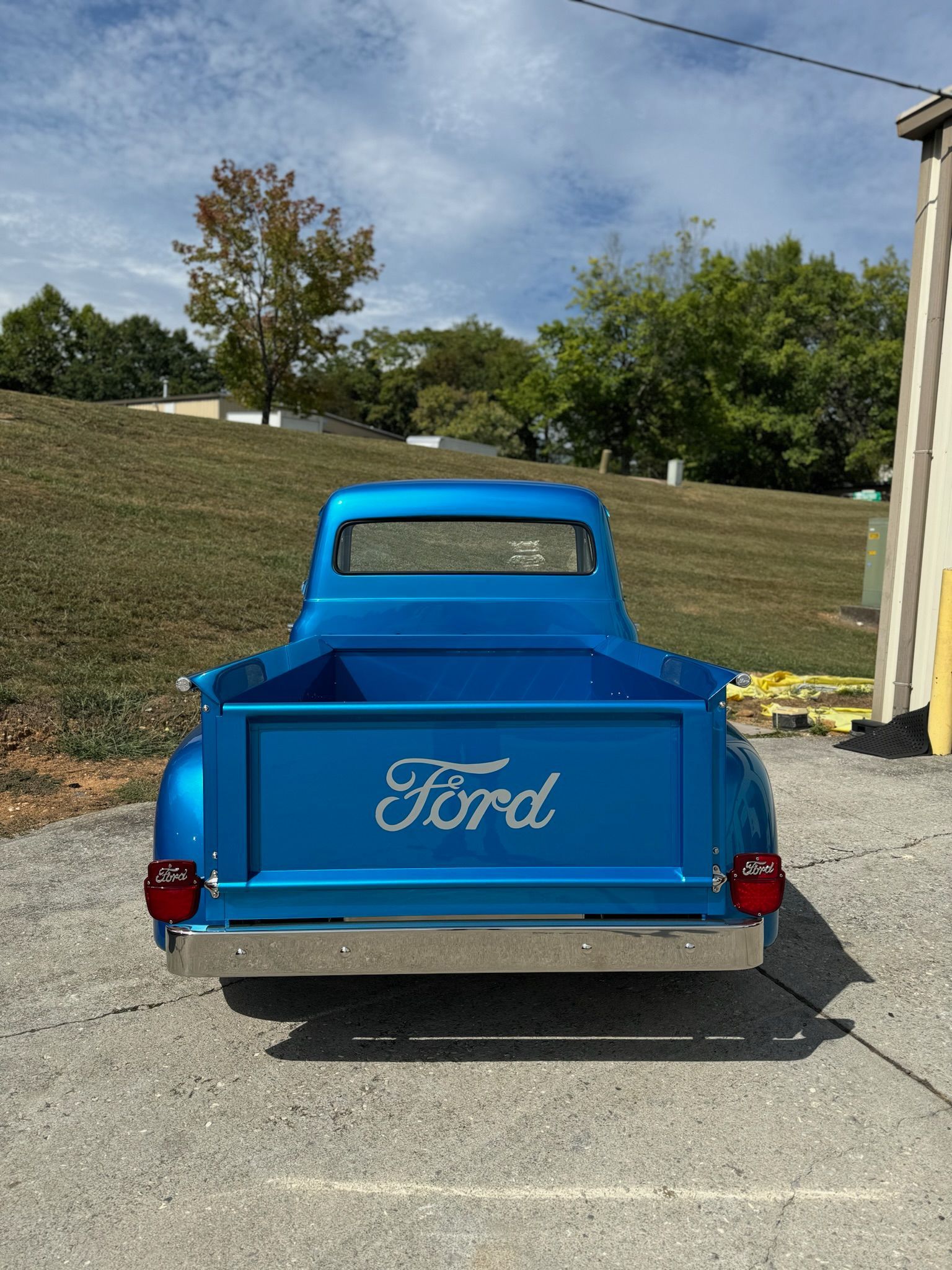 A blue ford truck is parked in a parking lot.