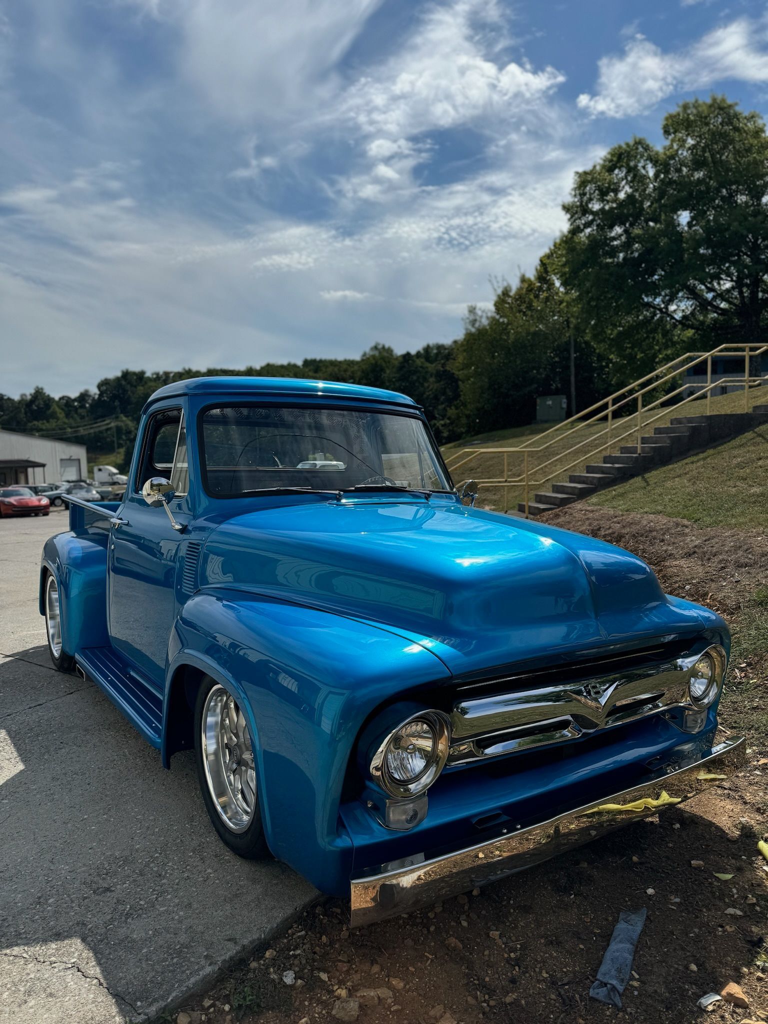 A blue pickup truck is parked on the side of the road.