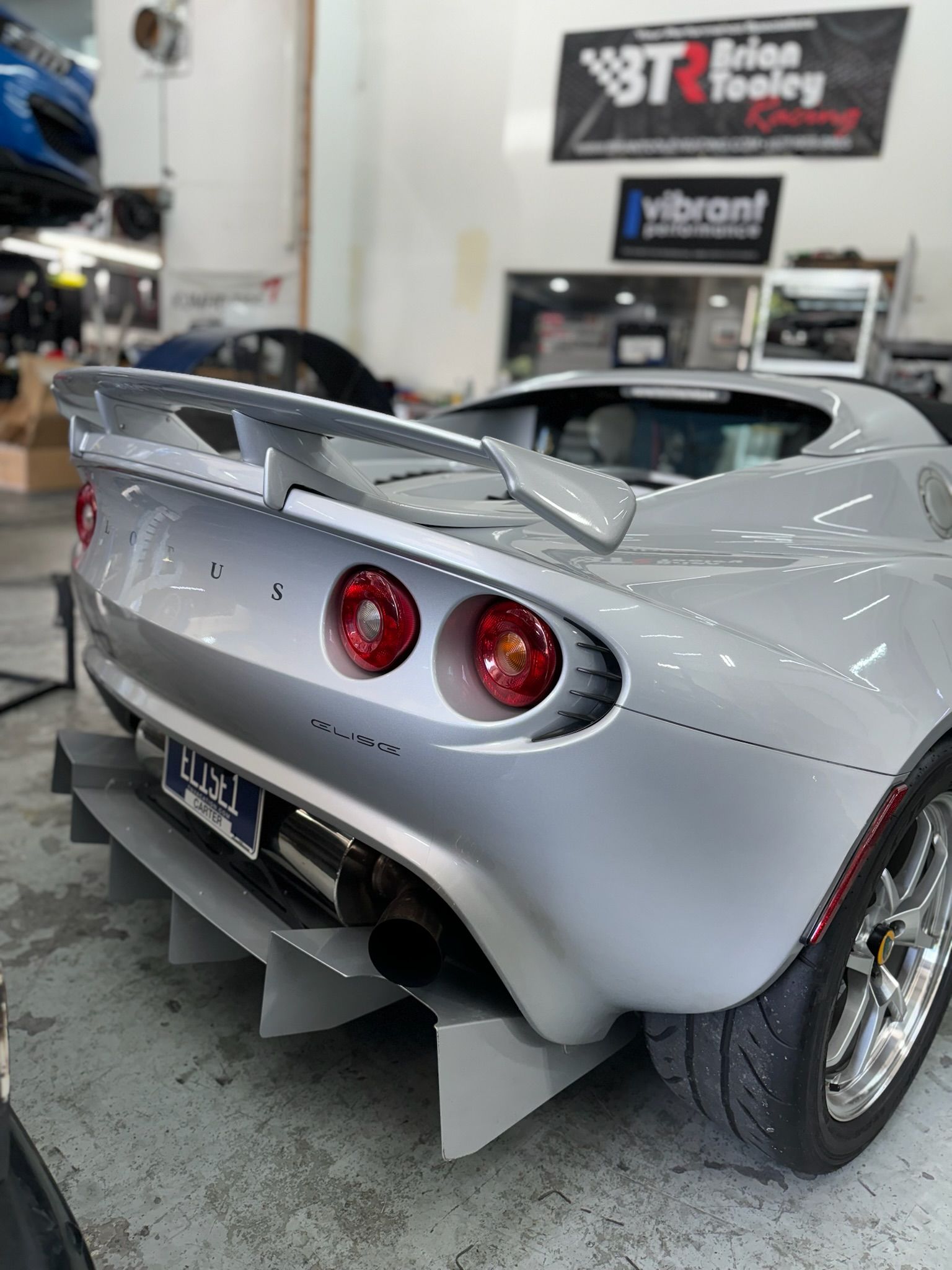A silver sports car is parked in a garage.