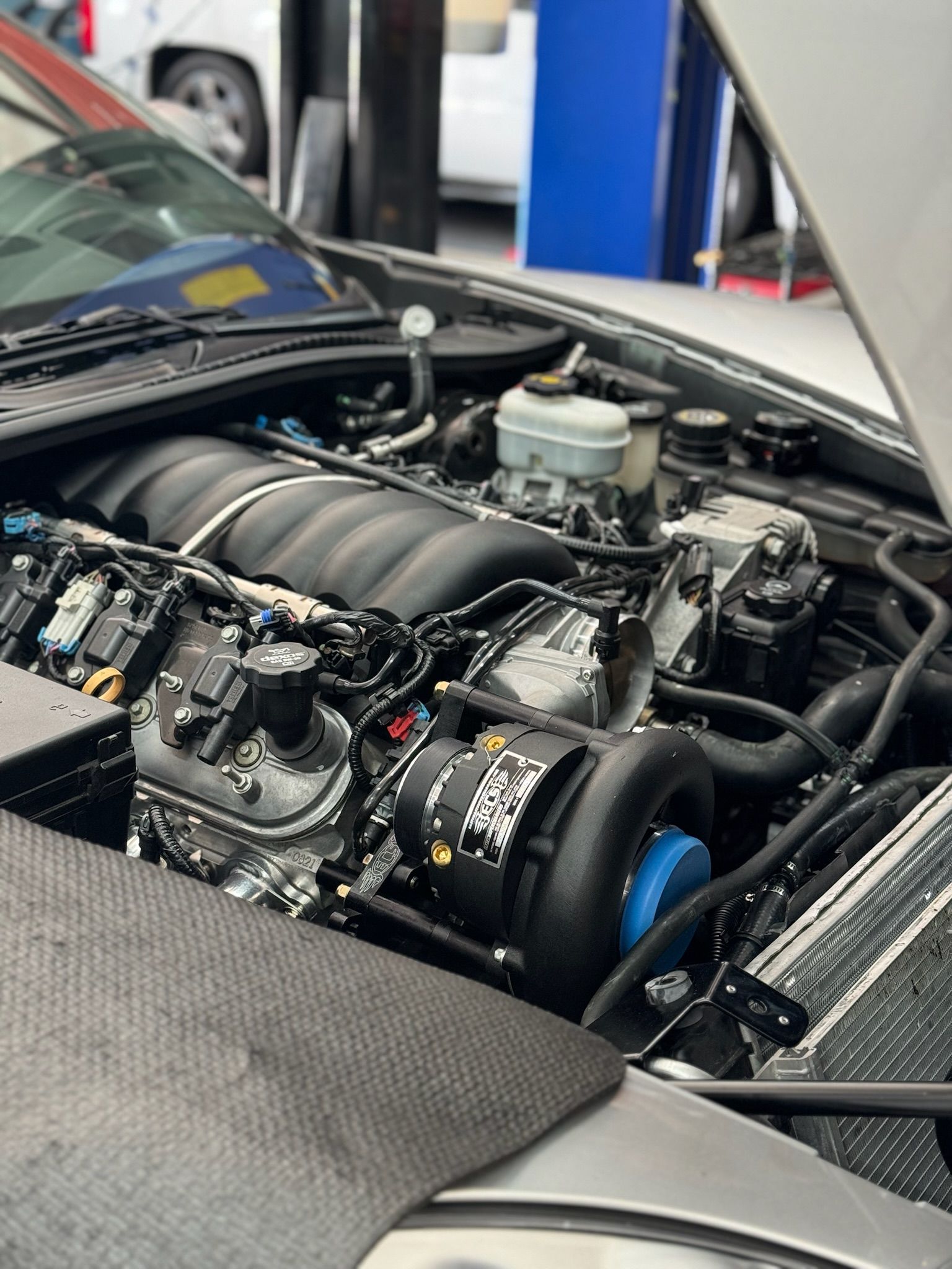 A close up of a car engine with the hood open