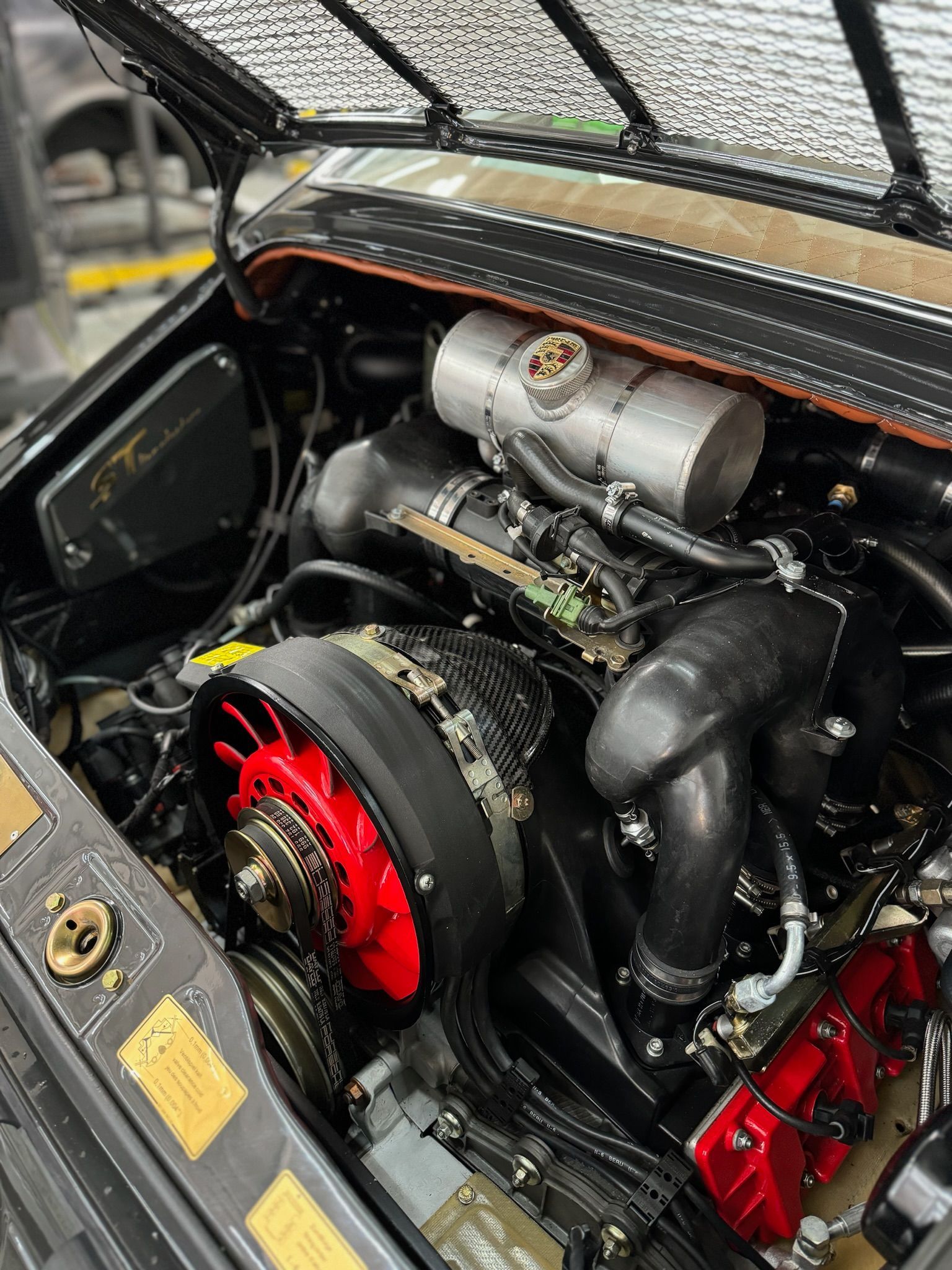 A close up of a car engine with the hood open.