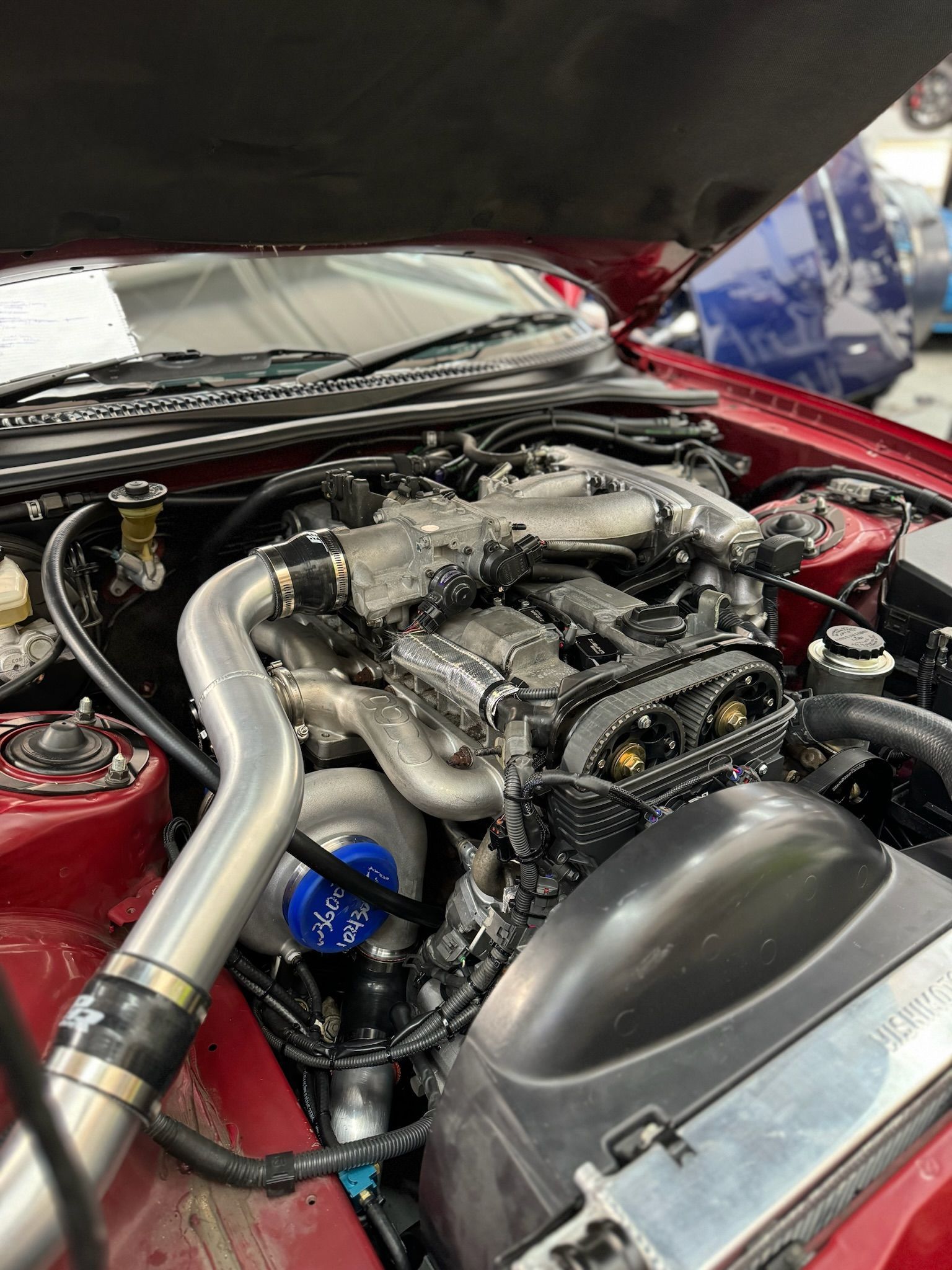 A close up of a car engine with the hood open.