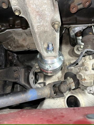 A close up of a car engine with a screw in it.