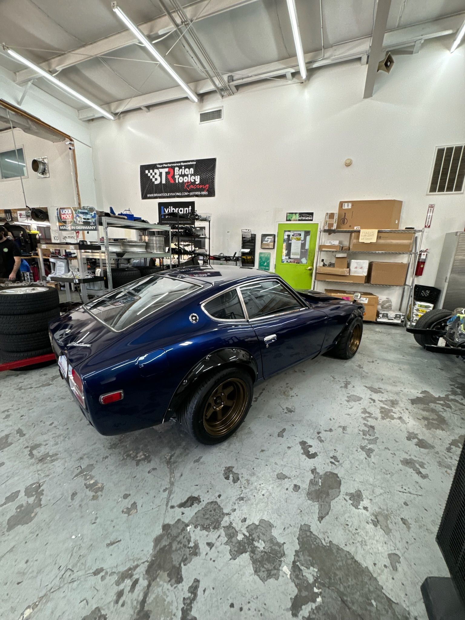 A blue sports car is parked in a garage.