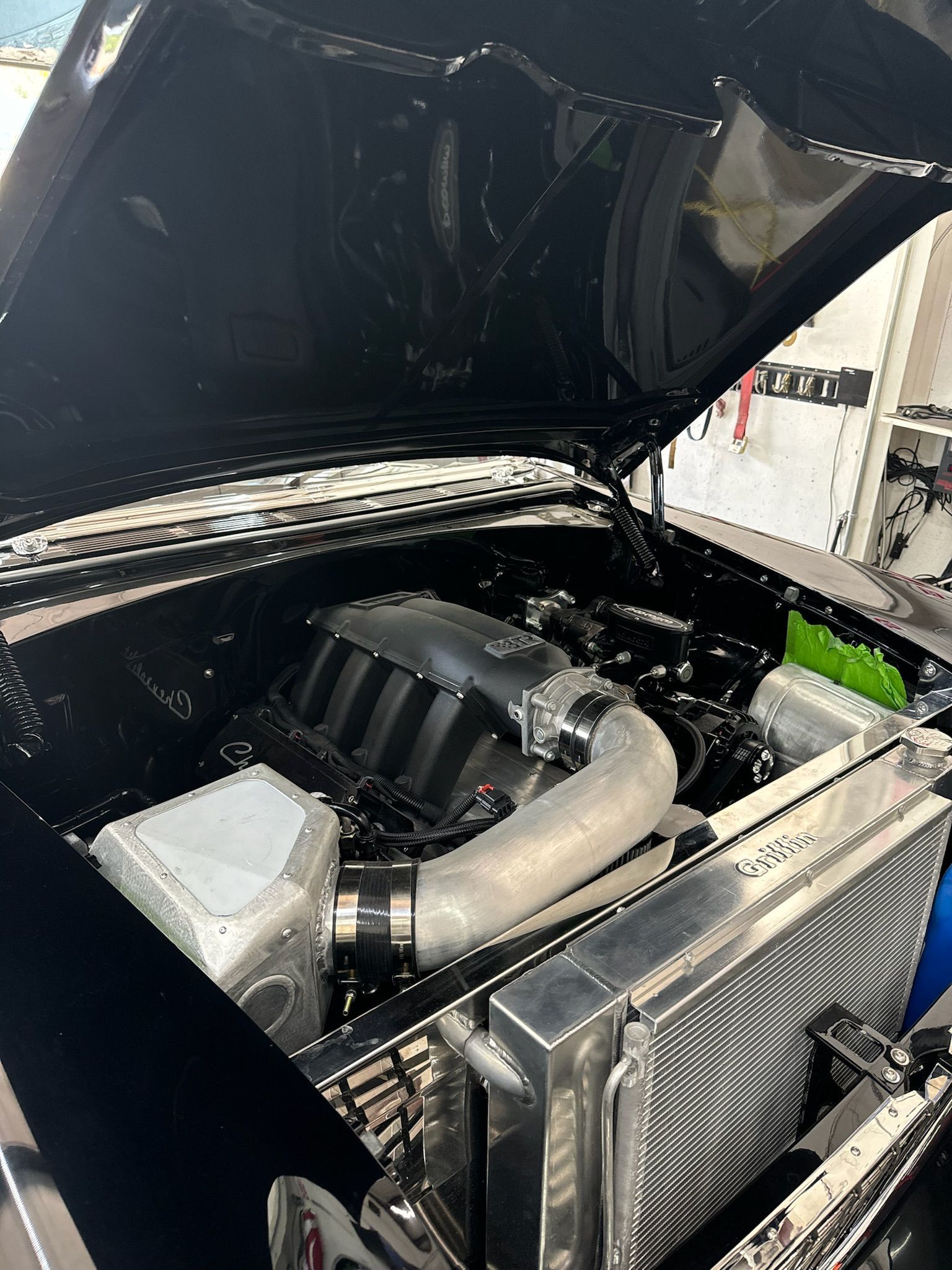 A close up of a car engine with the hood open.