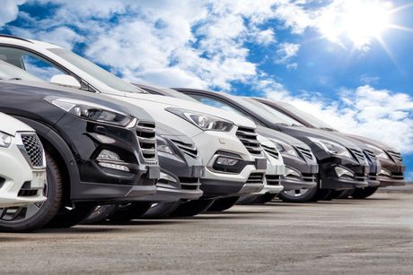 A row of cars are parked in a parking lot.