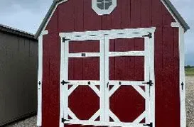 Red and white shed with double doors, octagonal accents, and a small window.