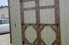 Tan and brown shed with decorative door panels.
