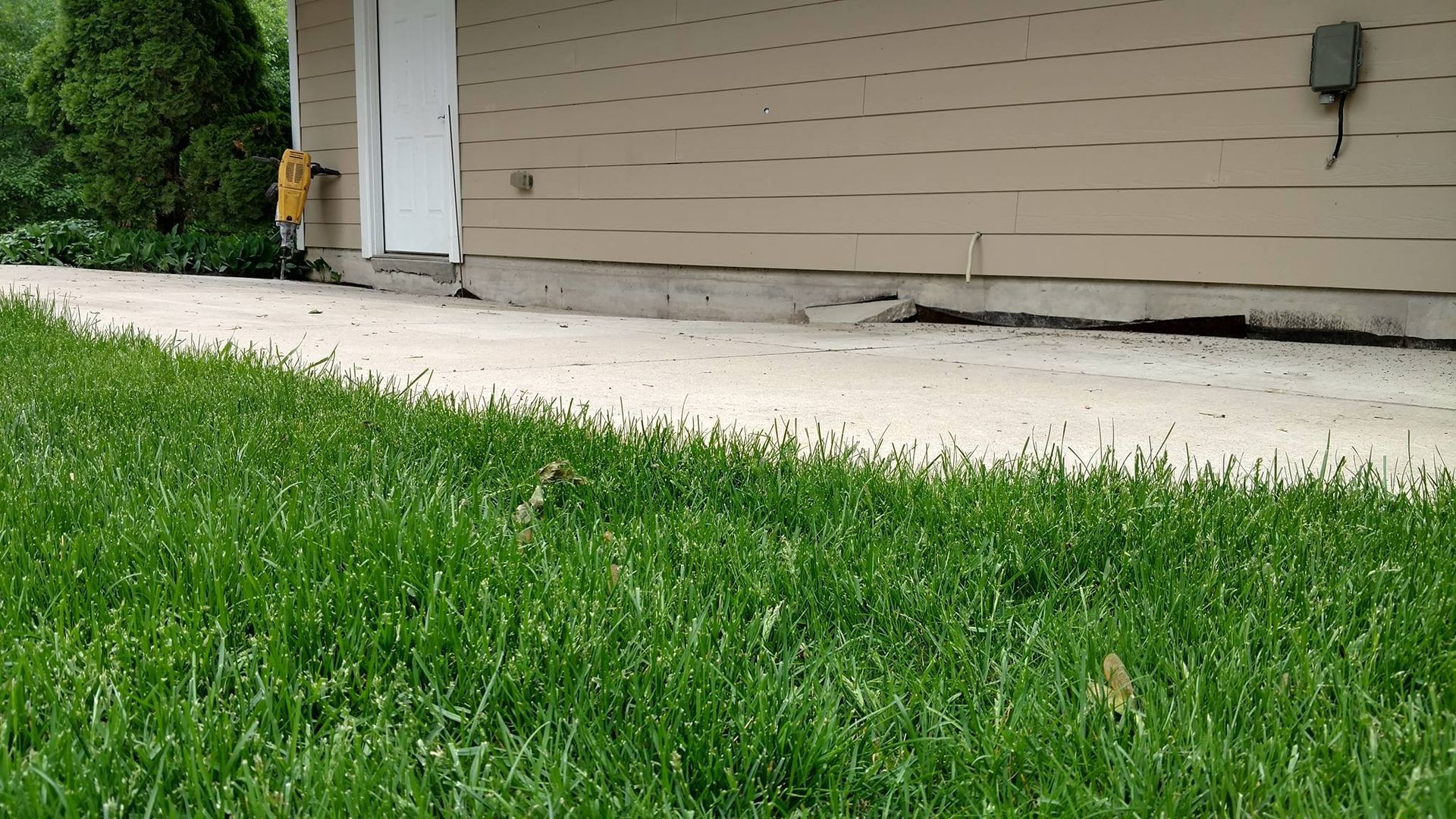 A lush green lawn in front of a house - before