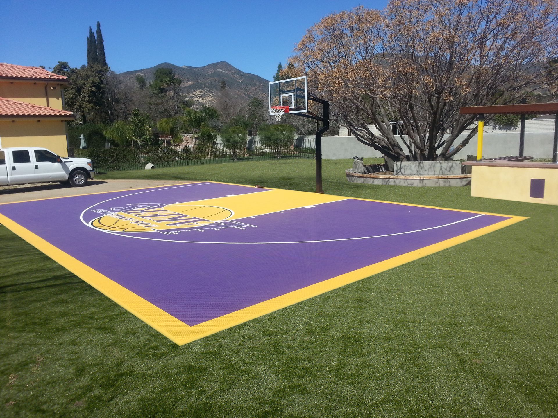 A purple and yellow basketball court with a truck parked in front of it