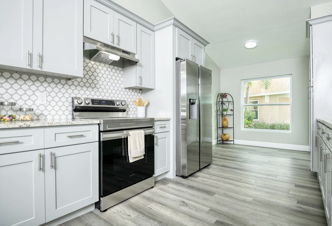 A kitchen with white cabinets and stainless steel appliances.