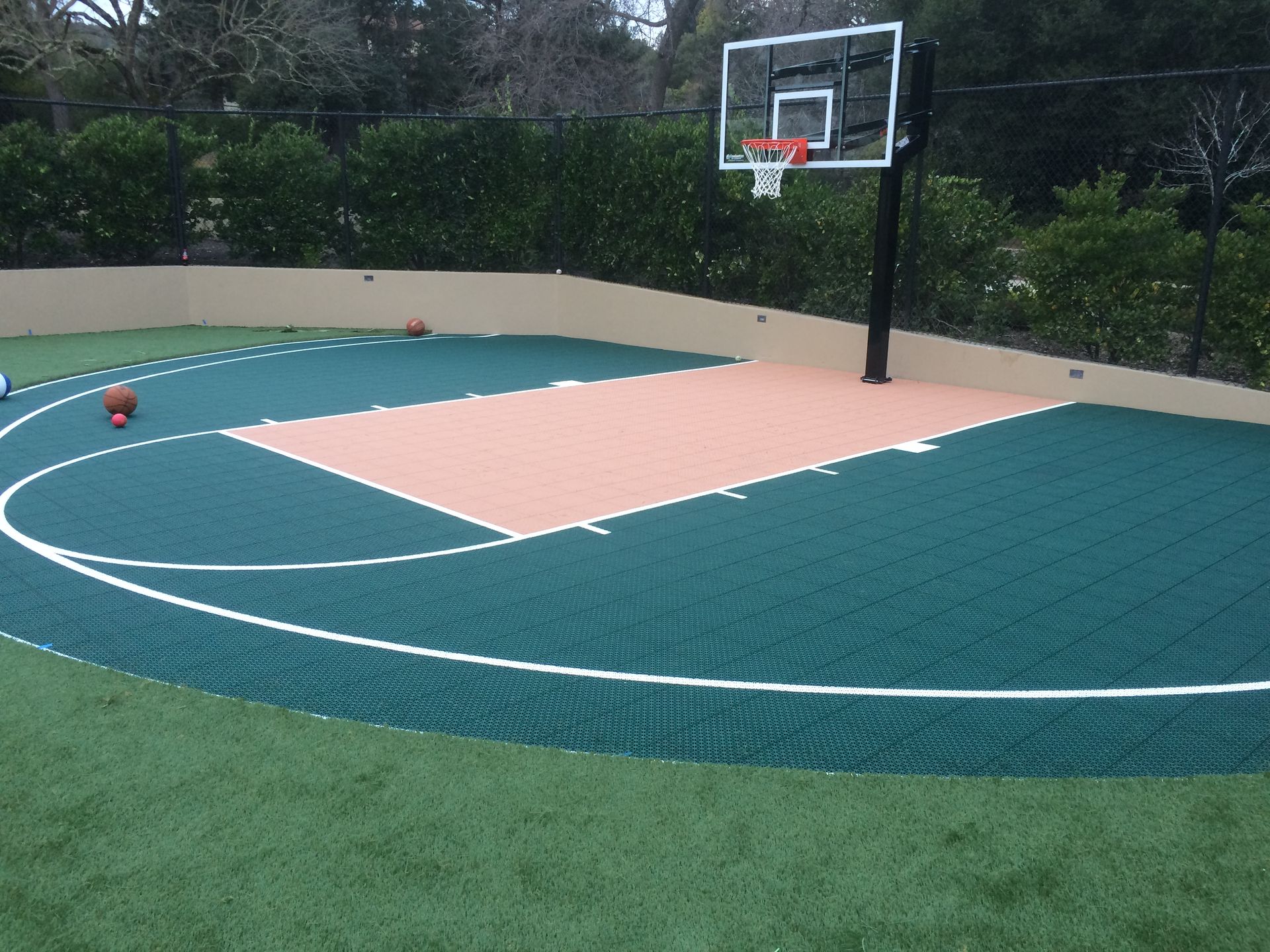 A basketball court with a hoop and a few balls on it