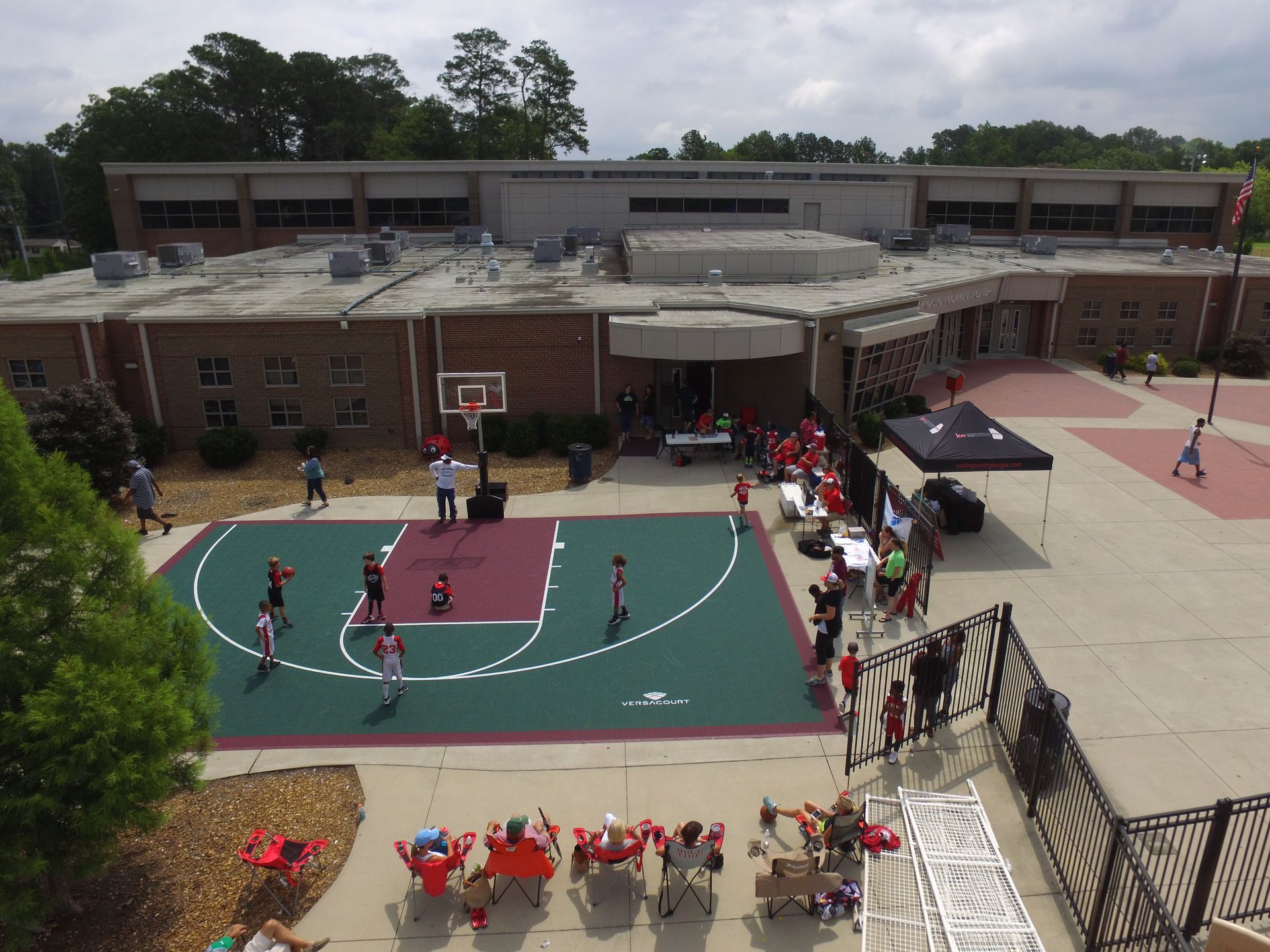 An aerial view of a basketball court in front of a school