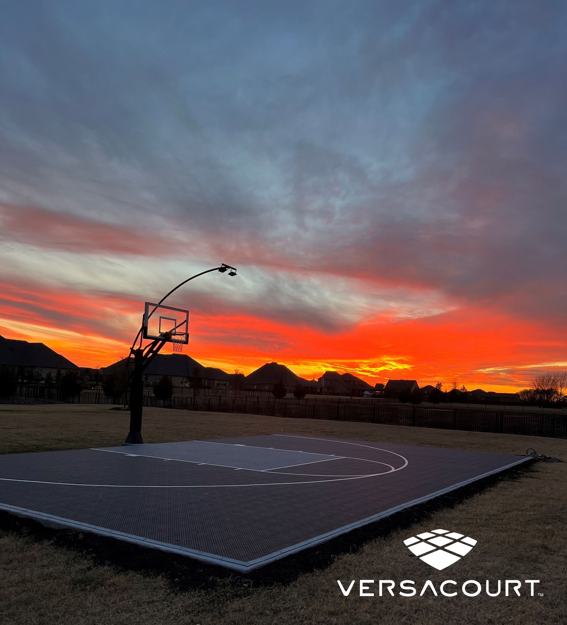 A basketball court with a sunset in the background.