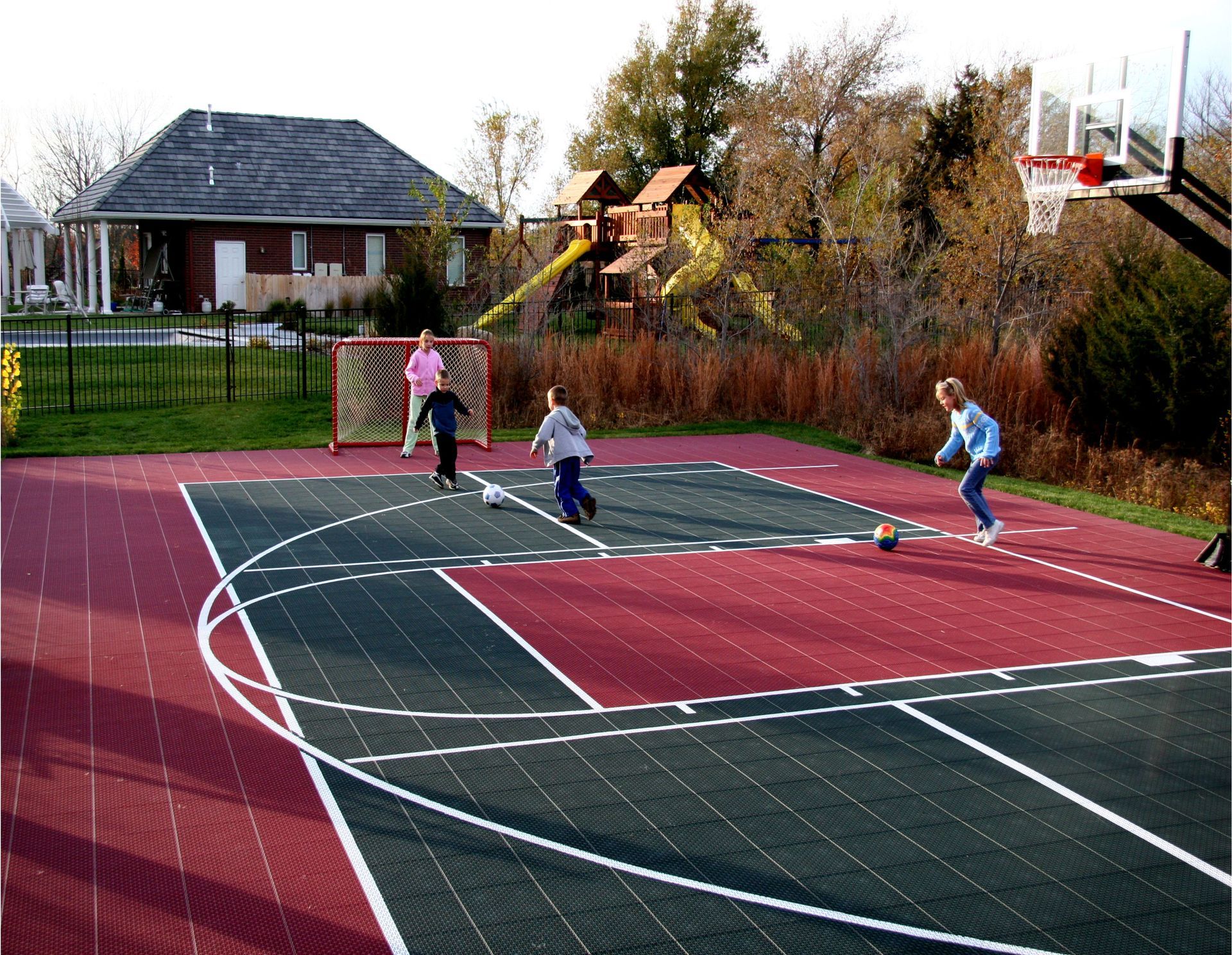 A group of children are playing soccer on a basketball court