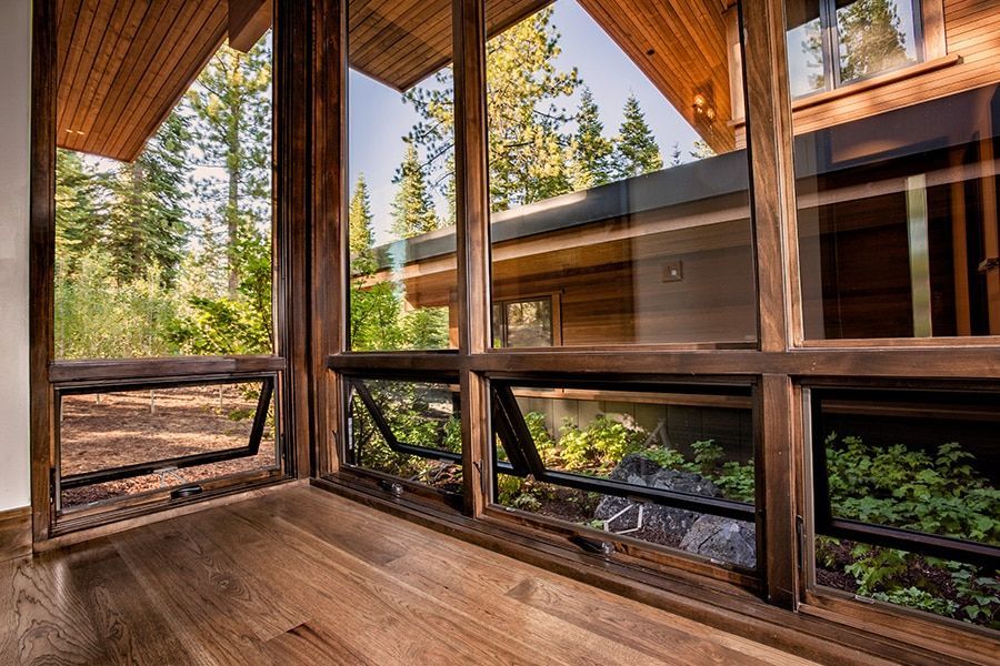 A room with a lot of windows and a wooden floor.