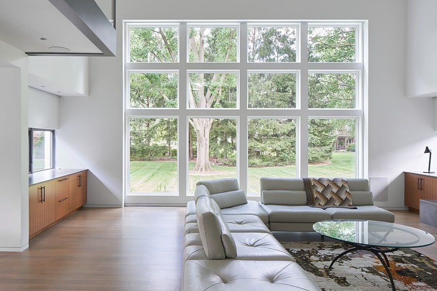 A living room with a couch , coffee table , and large windows.