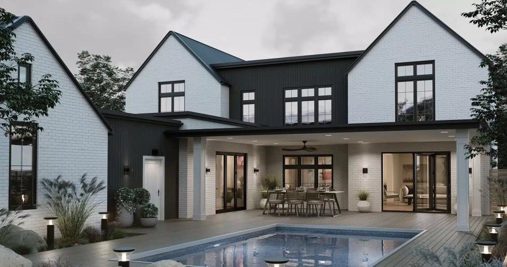 A large white house with a large swimming pool in front of it.