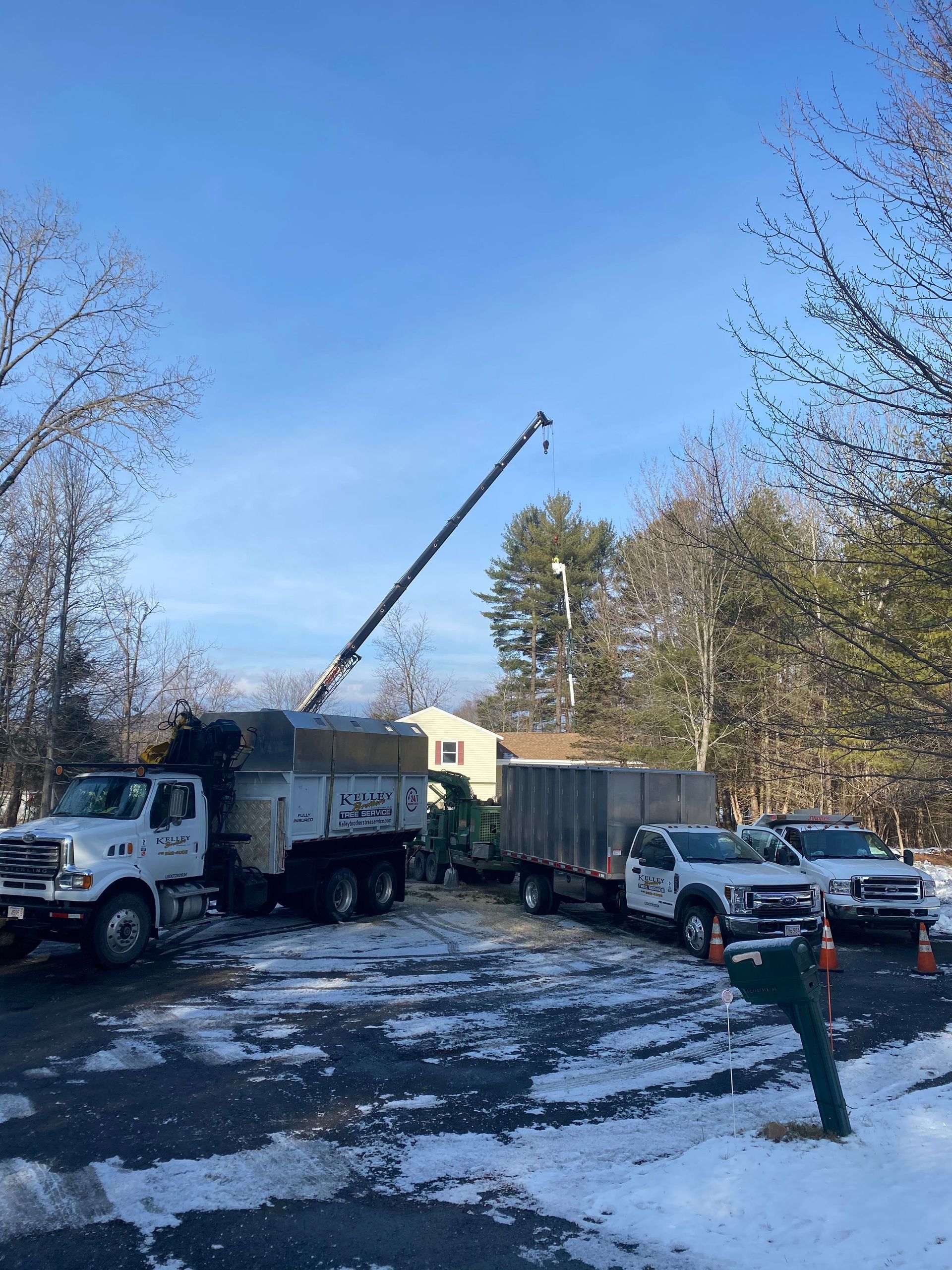 A group of trucks are parked in a snowy parking lot.
