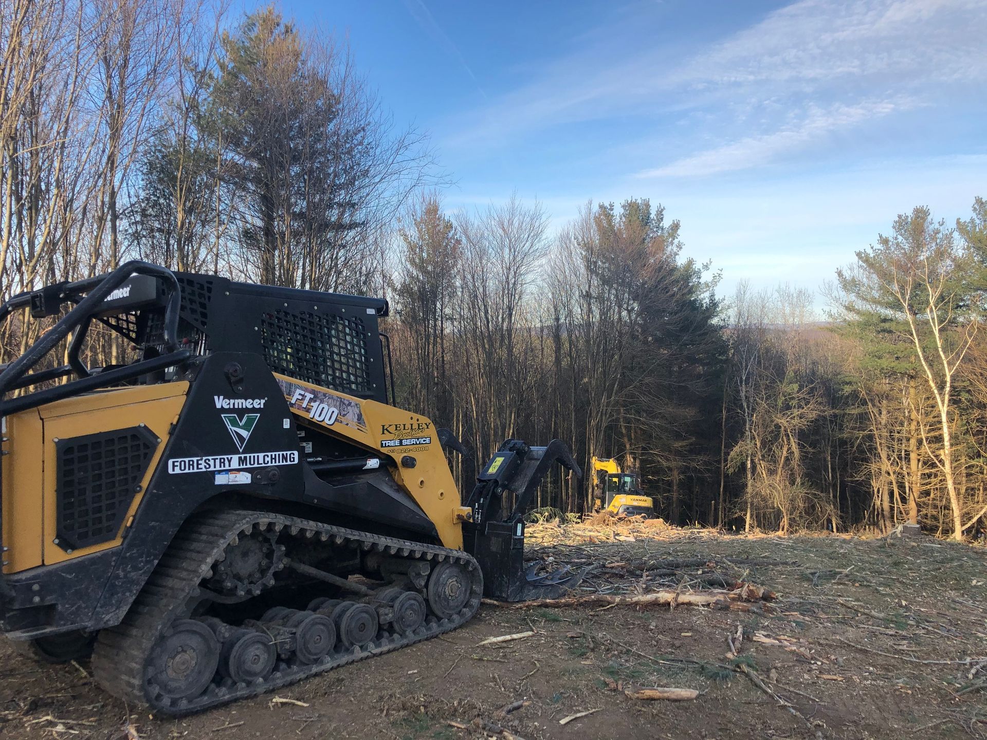 A bulldozer is sitting in a field with trees in the background.