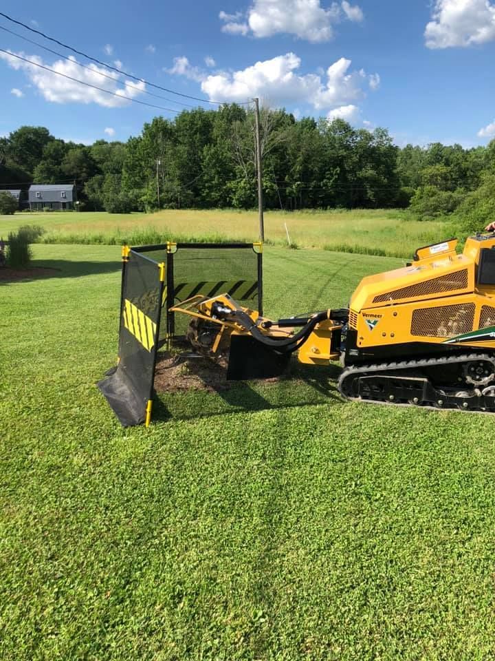 A yellow tractor is sitting in the middle of a lush green field.