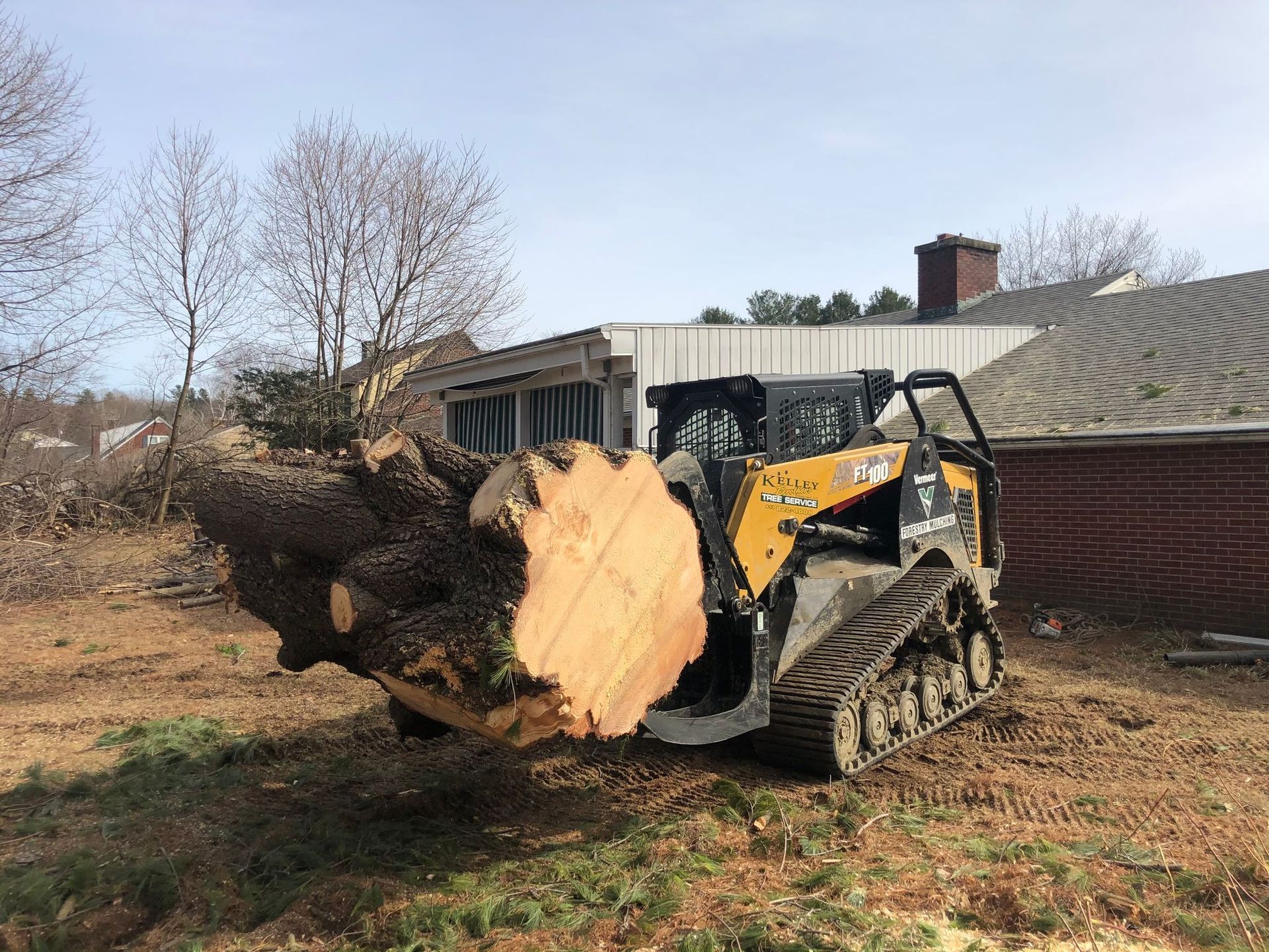A bulldozer is carrying a large log in a field.