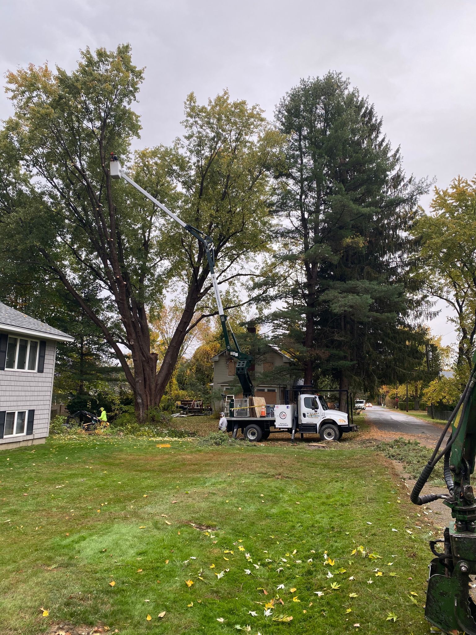 A tree cutting truck is parked in front of a house.