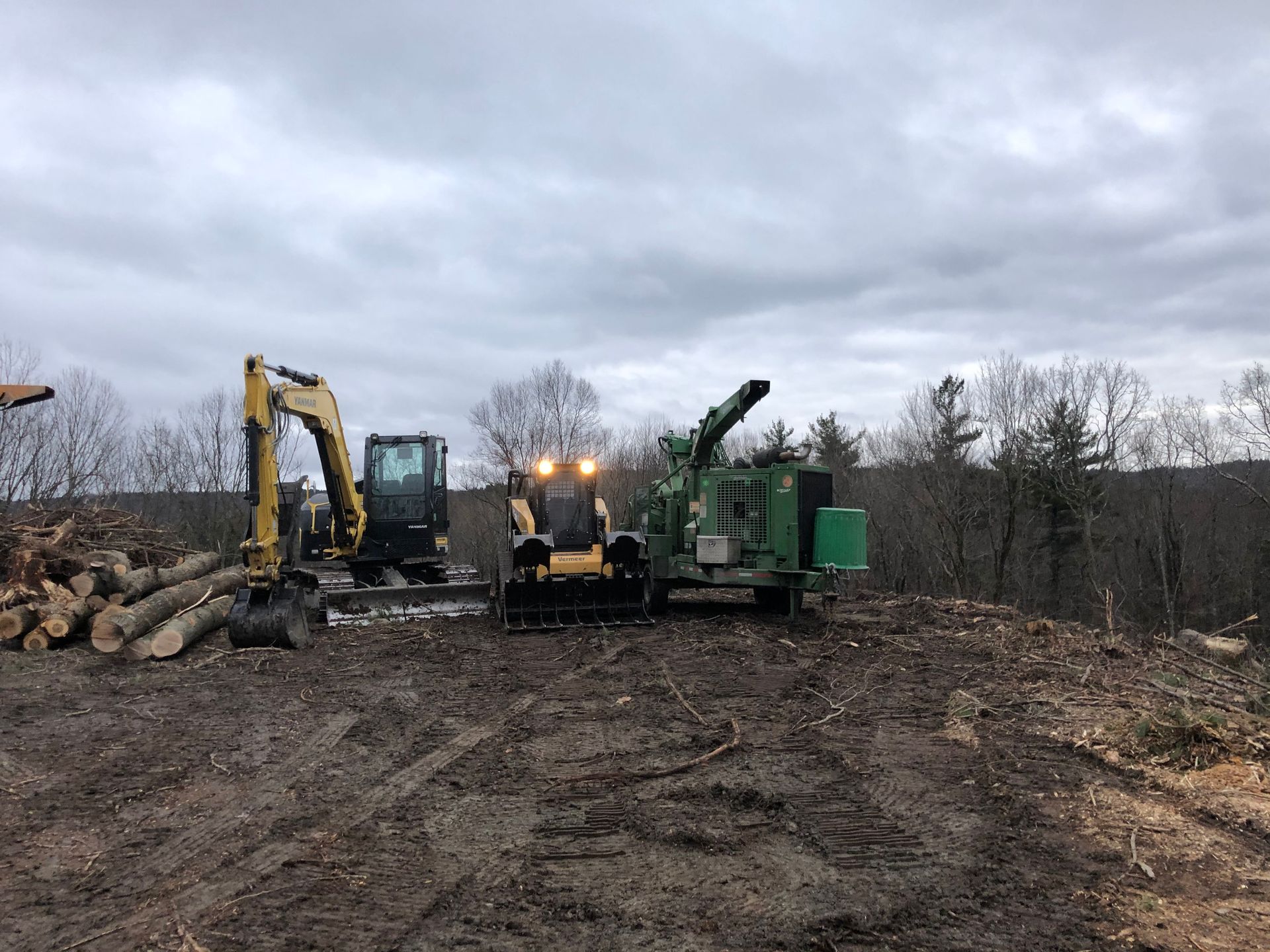 A couple of tractors are sitting in a dirt field.