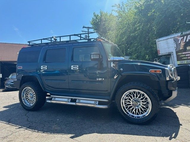 A hummer h2 suv is parked in front of a garage.