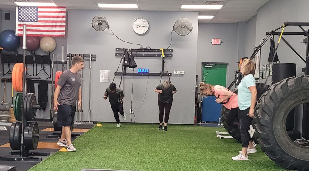 A group of people are doing exercises in a gym.