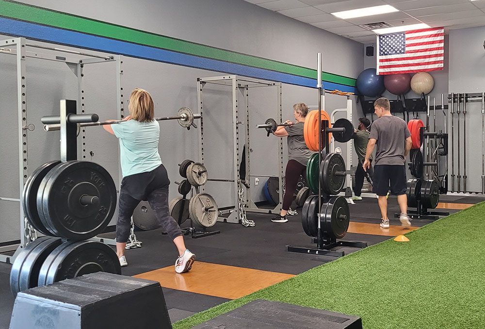 A group of people are doing squats in a gym.