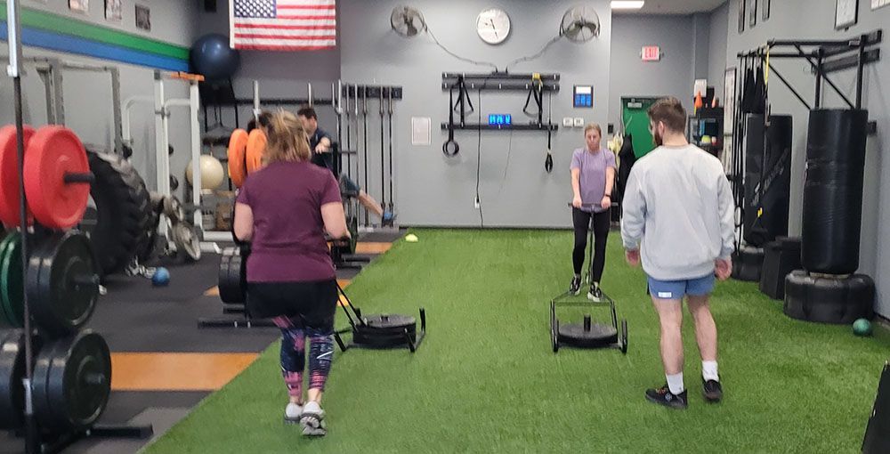 A group of people are doing exercises in a gym.