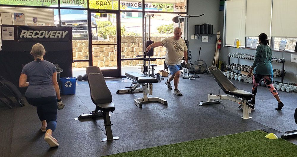 A group of people are doing exercises in a gym.