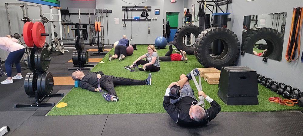 A group of people are doing exercises in a gym.