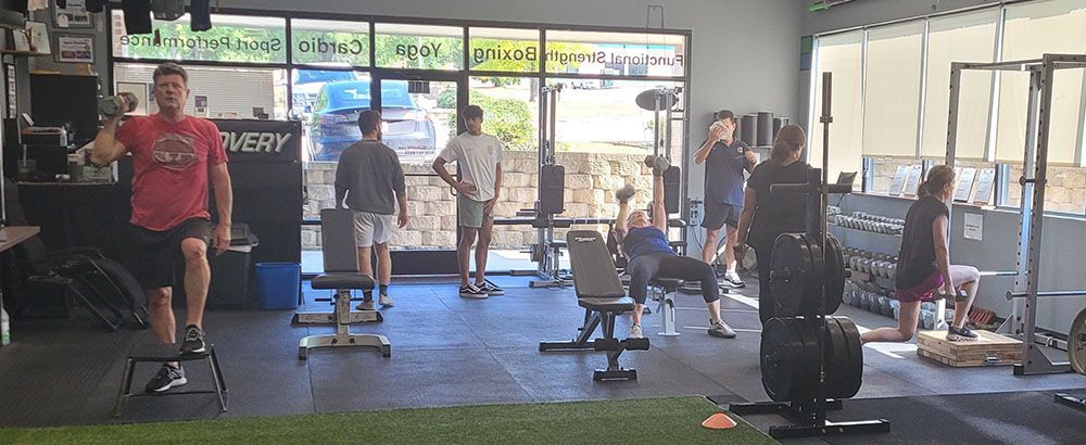 A group of people are standing in a gym.