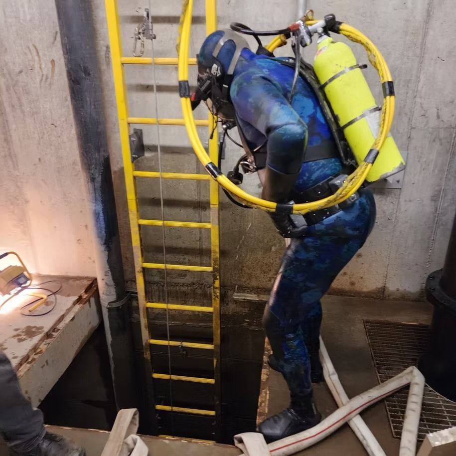 A man in a blue wet suit with a yellow hose around his neck