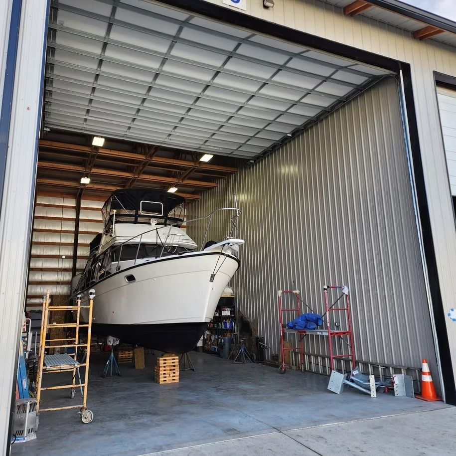 A boat is sitting in a garage with the door open