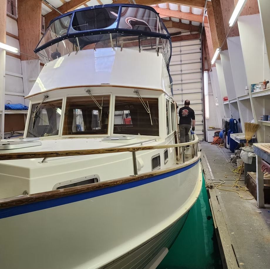 A man standing next to a boat in a garage