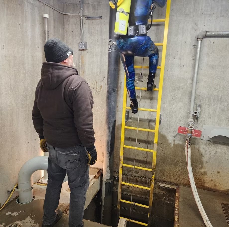 A man standing next to a man climbing a ladder