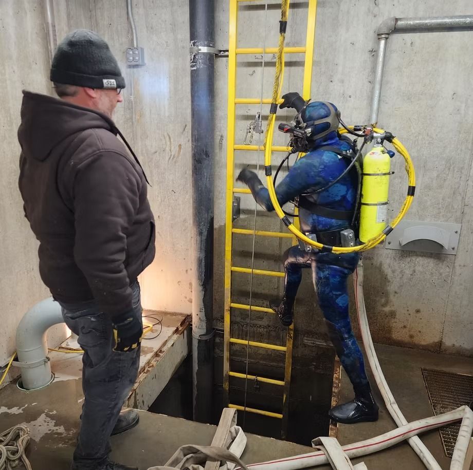 A man standing next to a scuba diver with a yellow ladder