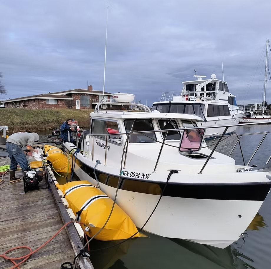 A boat is docked at a dock with a few people on it