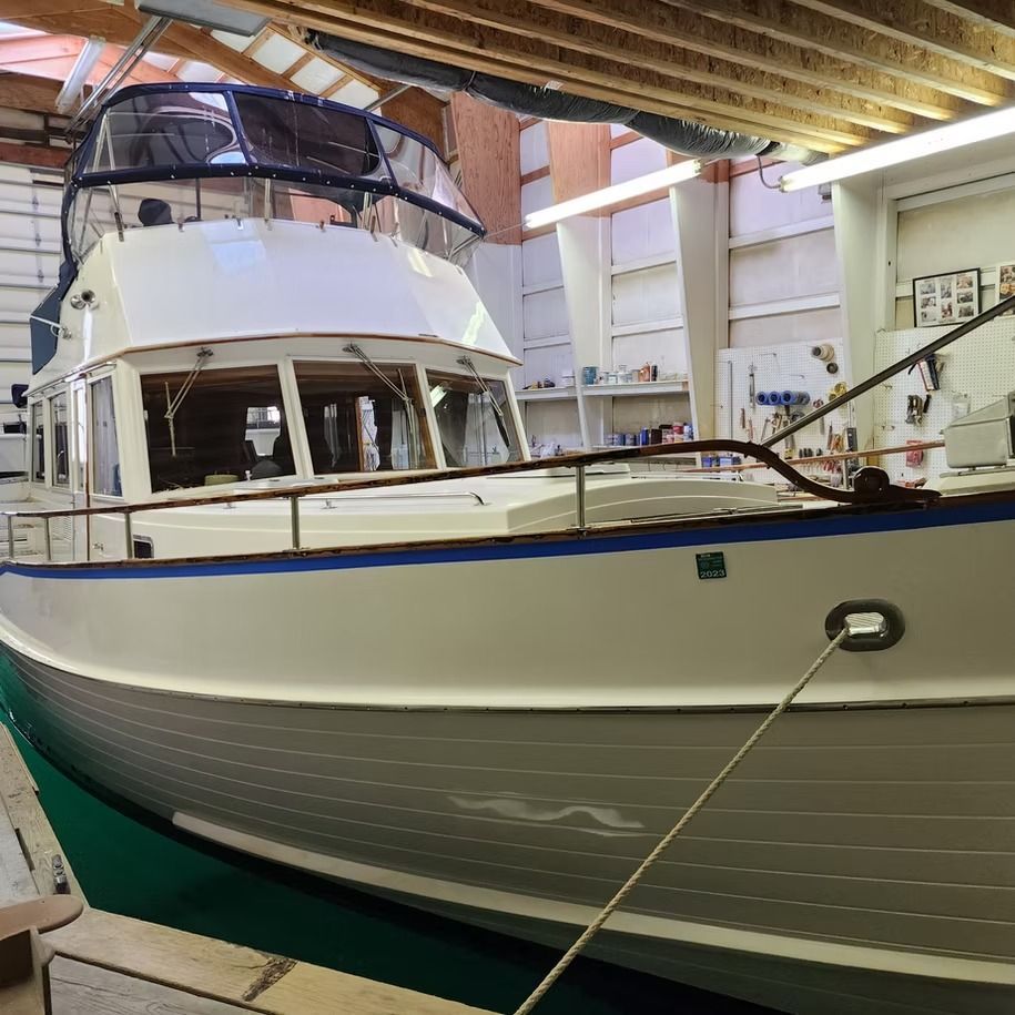 A large white boat is docked in a garage