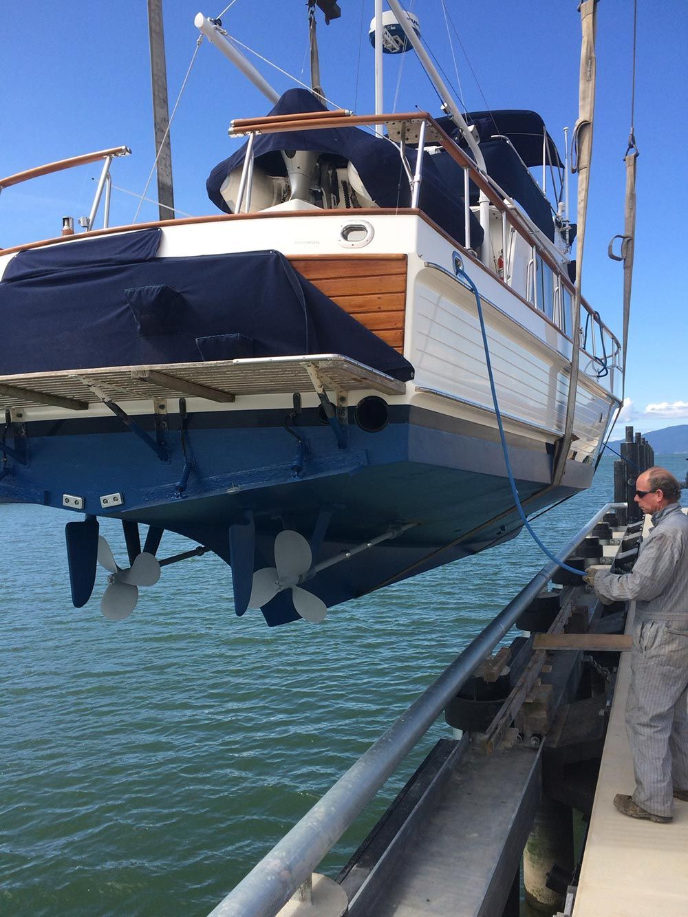 A boat is being lifted into the water by a crane