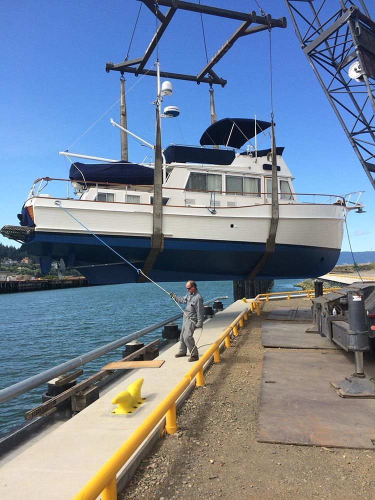 A boat is being lifted into the water by a crane