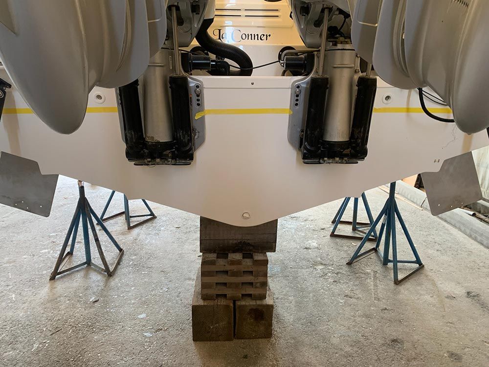 A boat is sitting on a wooden stand in a garage.