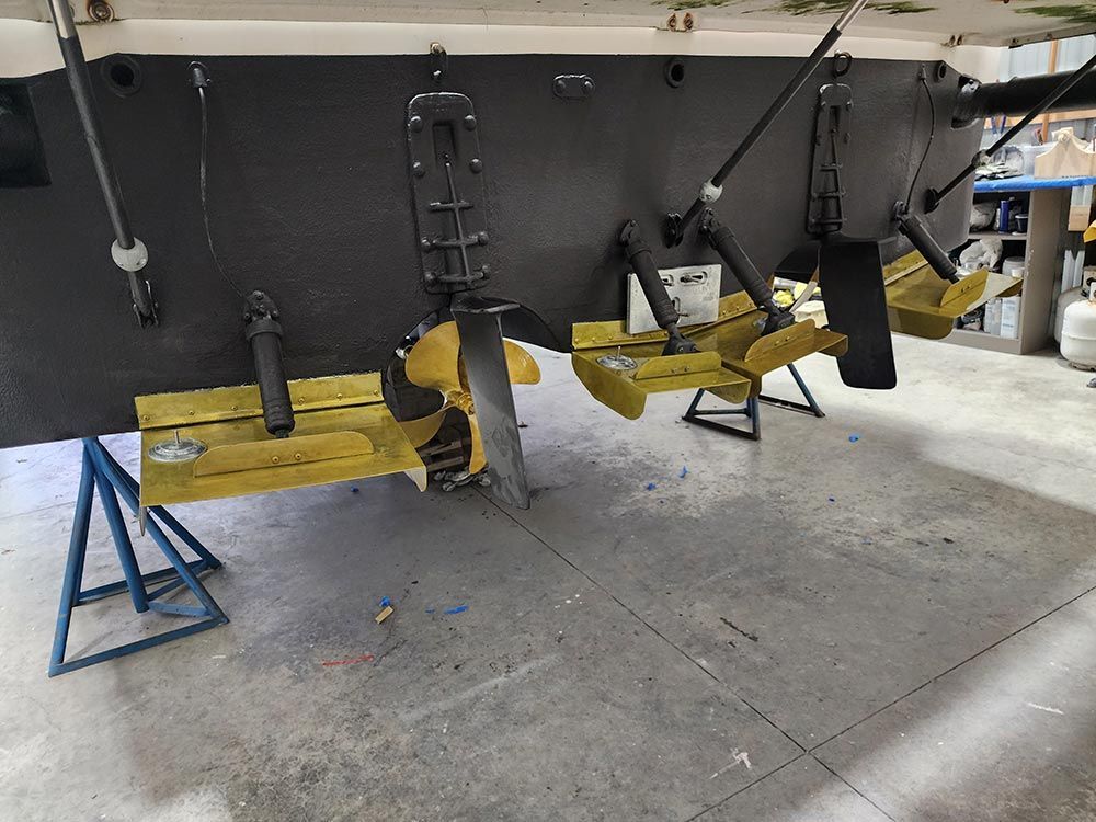 A boat is sitting on a concrete floor in a garage.