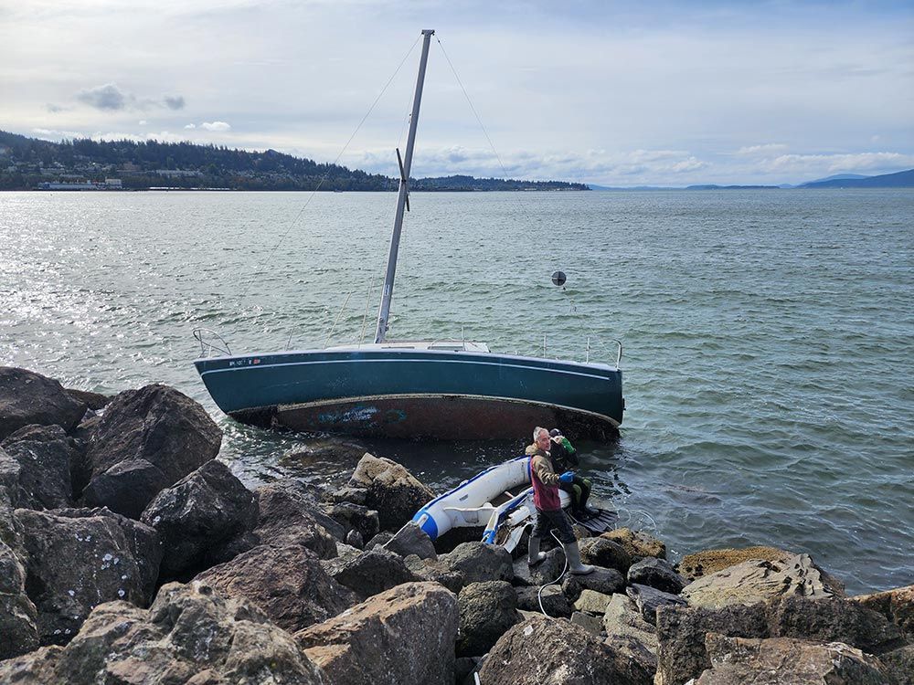 A person is standing next to a boat in the water.